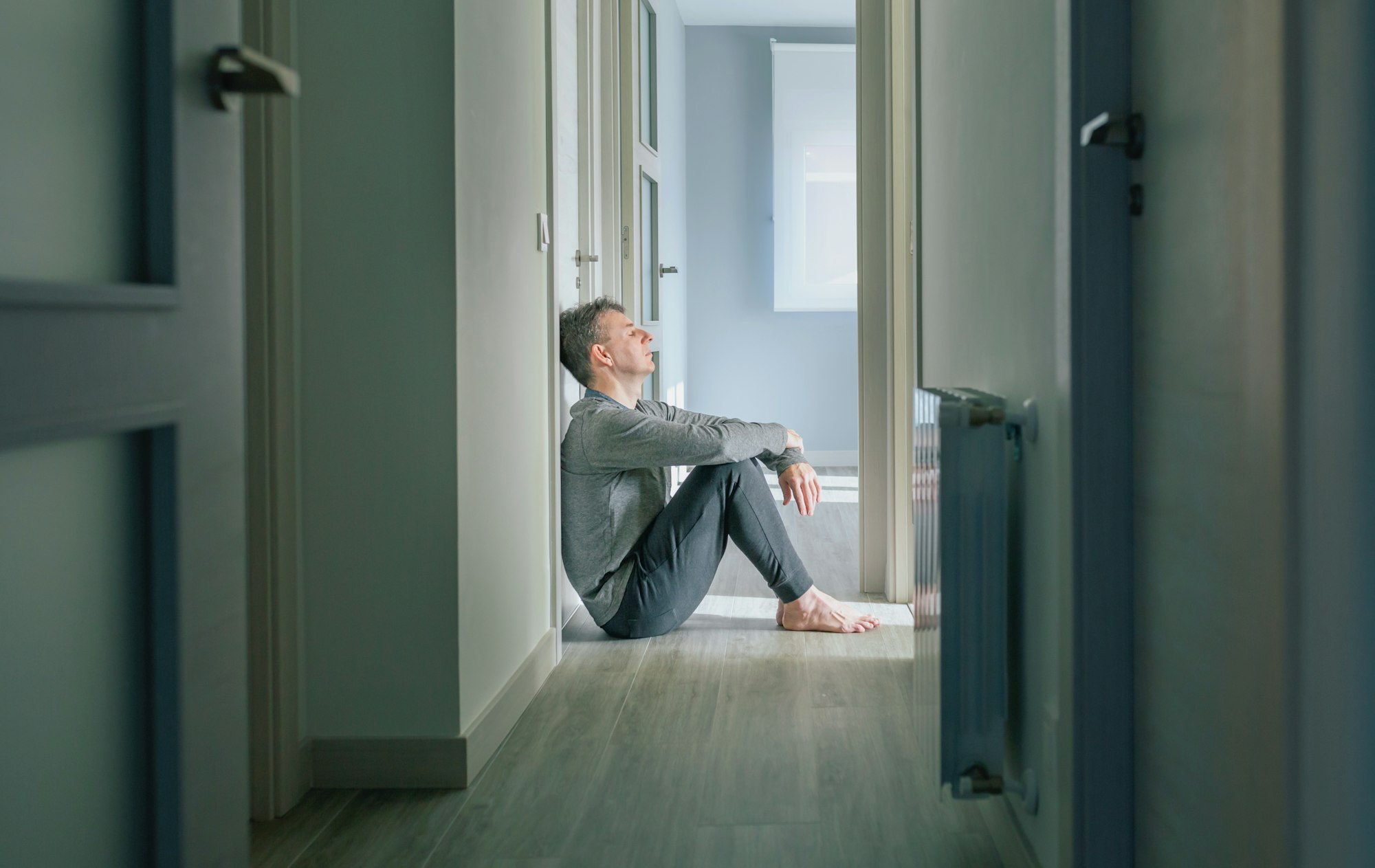 Man with mental disorder sitting on the floor